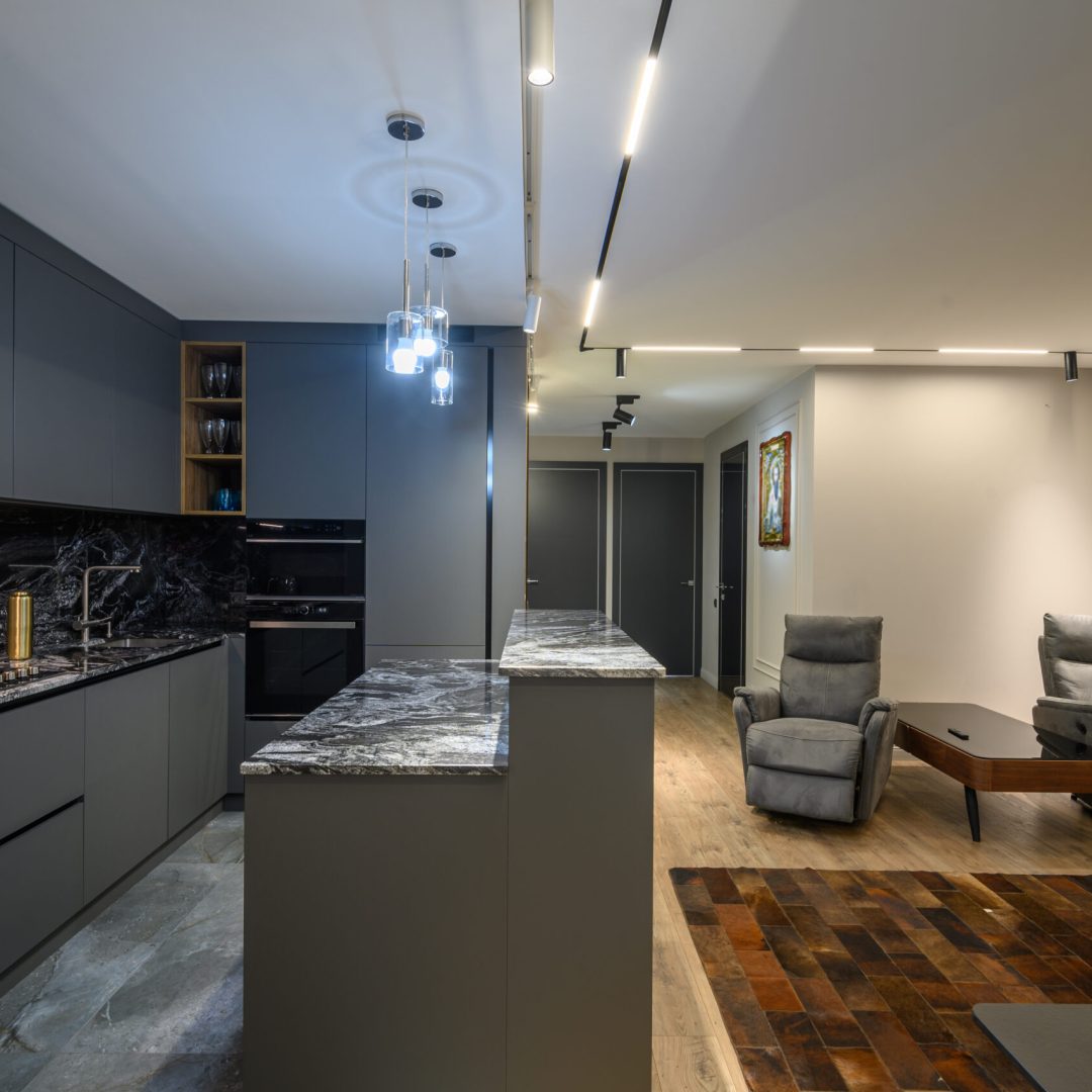 Luxury living room with massage chairs and grey kitchen in studio apartment interior